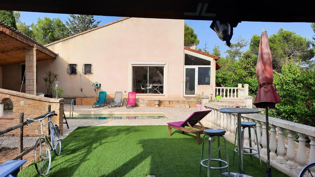 a backyard with a lawn with chairs and a pool at Villa de 2 chambres avec piscine privee jardin clos et wifi a Merindol in Mérindol