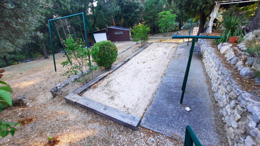 a garden with a swing set in a yard at Villa de 2 chambres avec piscine privee jardin clos et wifi a Merindol in Mérindol