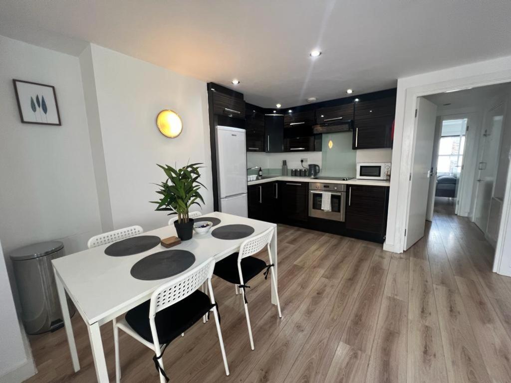 a kitchen with a white table and chairs in a room at Full Apartment! Brick Lane! in London