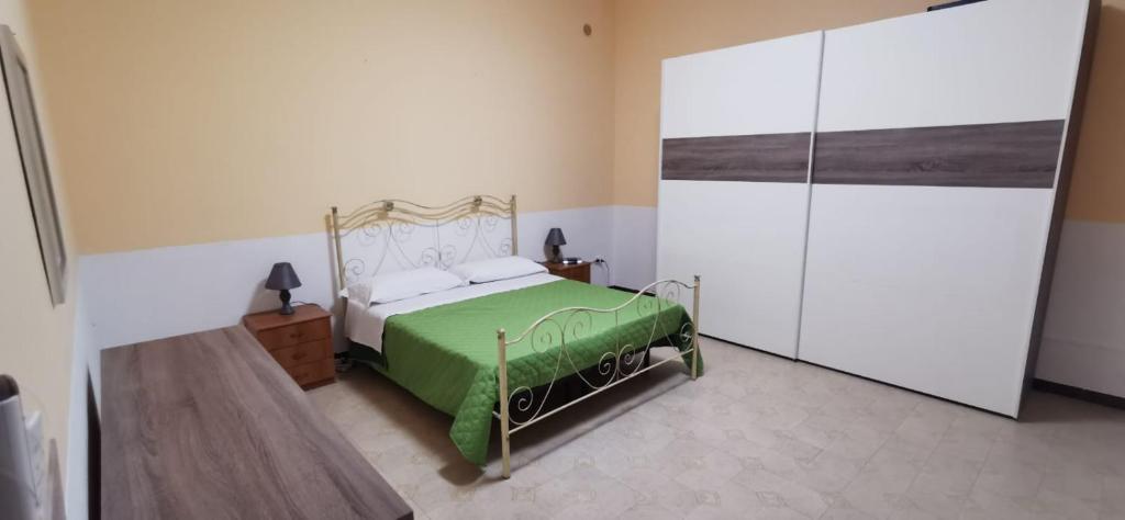 um quarto com uma cama verde e branca num quarto em Casa Falconara em Noto Marina