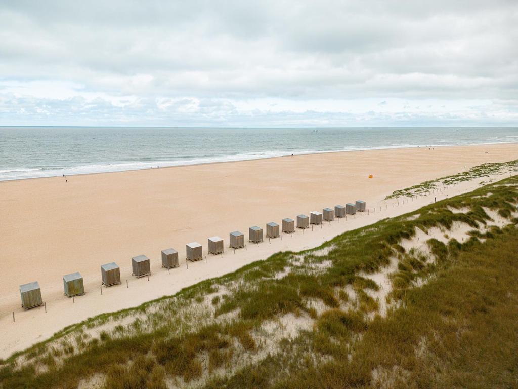 an aerial view of a beach with a row of chairs at Glamping Callantsoog in Callantsoog