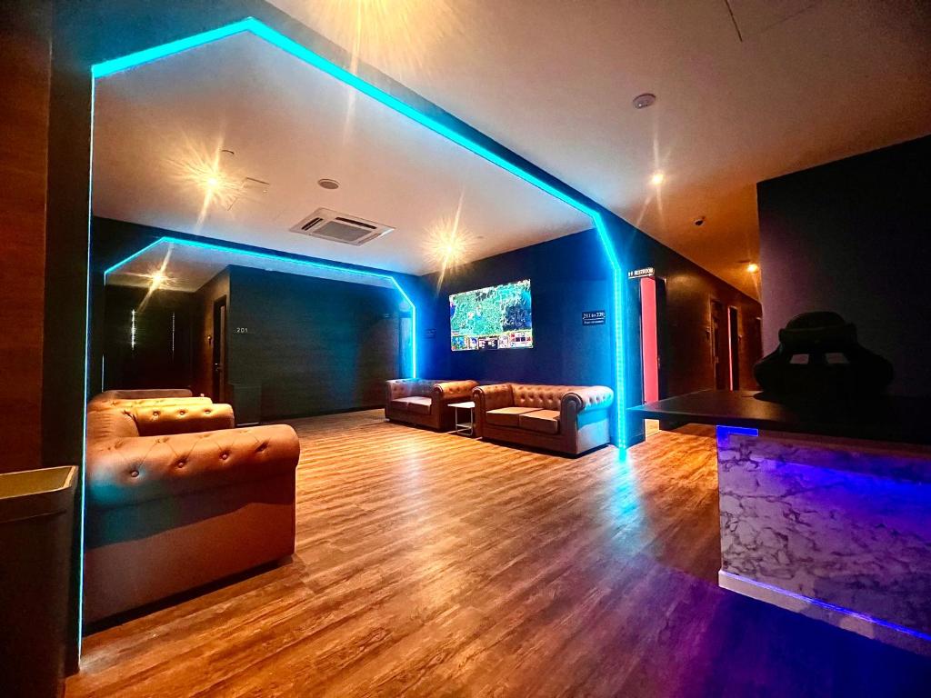 sala de estar con sofás, TV y luces azules en Arena eSports @ Orchard en Singapur