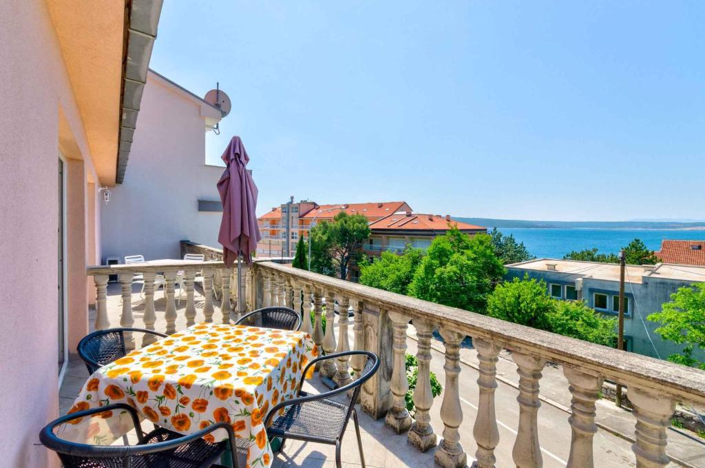 a table and chairs on a balcony with an umbrella at Apartment in Crikvenica with One-Bedroom 3 in Crikvenica