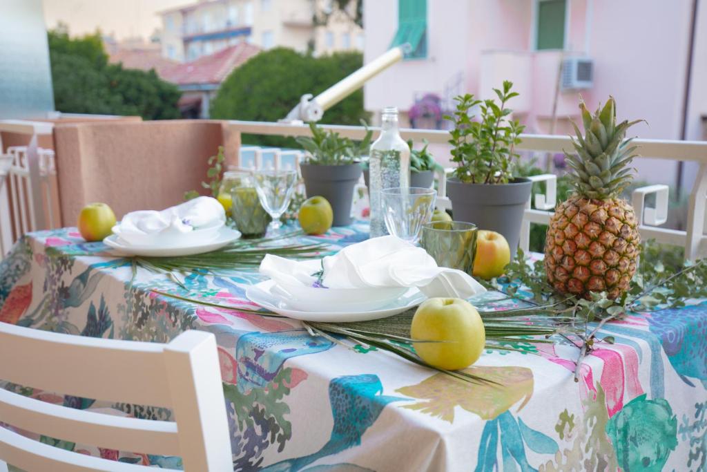 een tafel met een ananas en borden erop bij Casa Vacanza di Monica in Bordighera