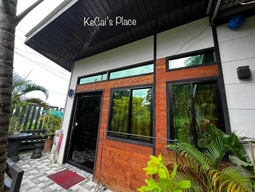 a building with a wooden door with a sign on it at KeCai’s Place in Digos