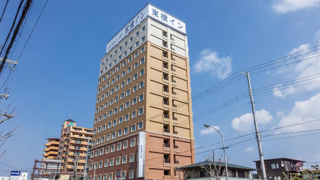 a tall building with a sign on top of it at Toyoko Inn JR Wakayama eki Higashi guchi in Wakayama