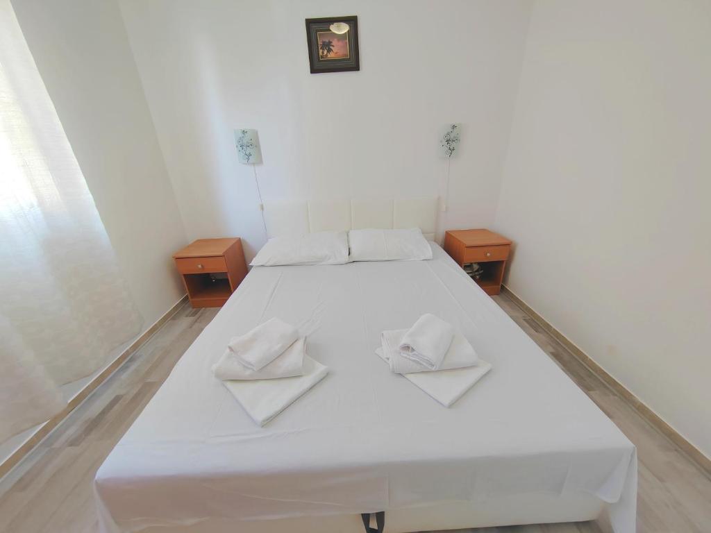 a white bed with two white towels on it at Apartment Zvonko in Stara Novalja