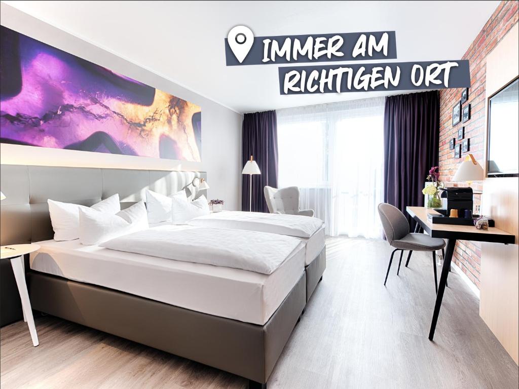 a hotel room with a bed and a desk at ACHAT Hotel Offenbach Plaza in Offenbach