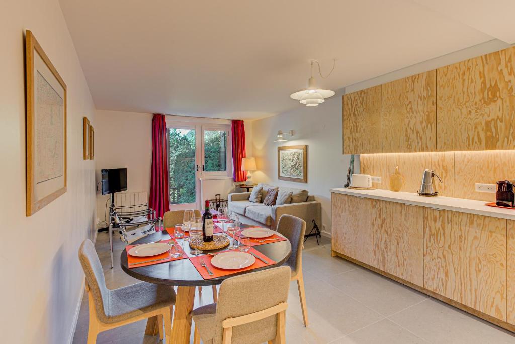 Il comprend une cuisine et un salon avec une table et des chaises. dans l'établissement Apartment Chapeau, Mont Blanc View, Alpes Travel, à Chamonix-Mont-Blanc