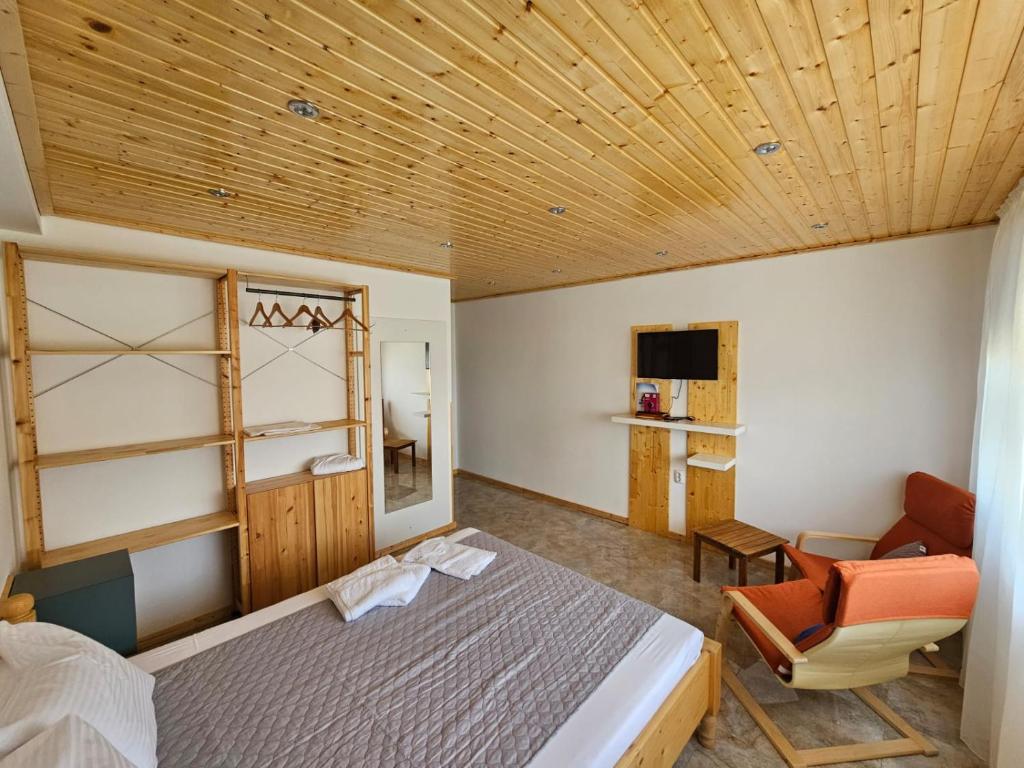 a bedroom with a bed and a chair in a room at Casuta Noastra - Sulina in Sulina