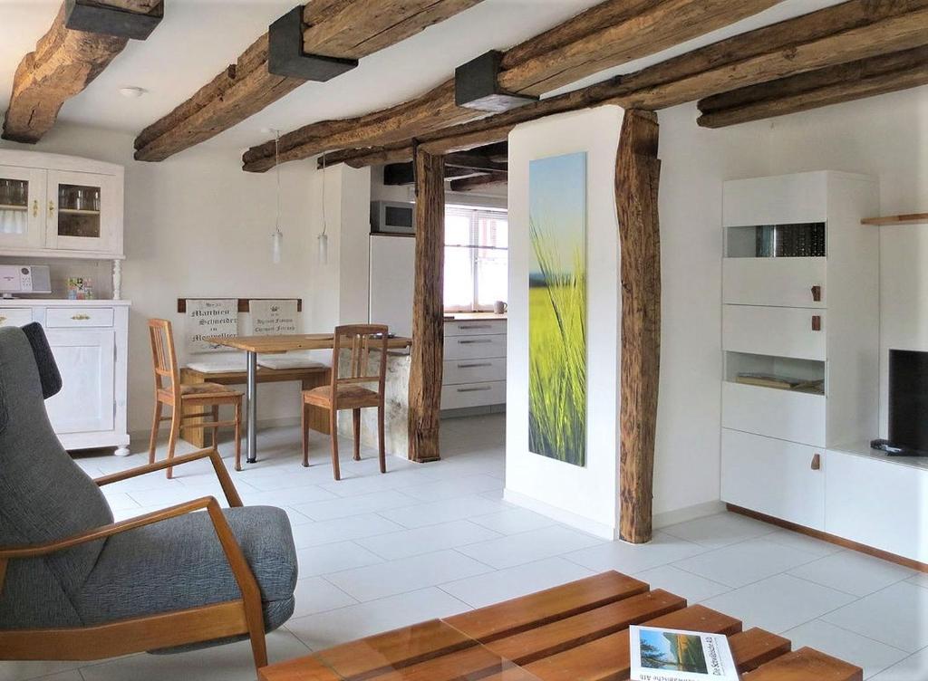Schopfloch的住宿－Ferienwohnung Die Schmiede，厨房以及带桌椅的起居室。