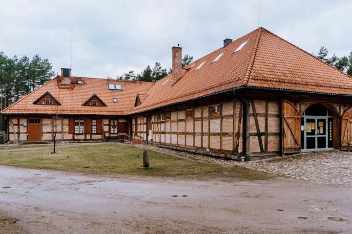 a large wooden building with a red roof at Gościniec Rzemyk in Wdzydze Kiszewskie