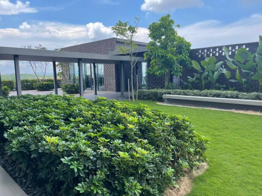 una casa con un gran arbusto delante de ella en Sunway Gandaria 3BR Full AC w/ Pool Wi-Fi Netflix en Bandar Baru Bangi