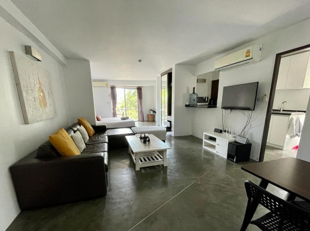 uma sala de estar com um sofá e uma mesa em Spacious Apartment by the Sea em Bangrak Beach