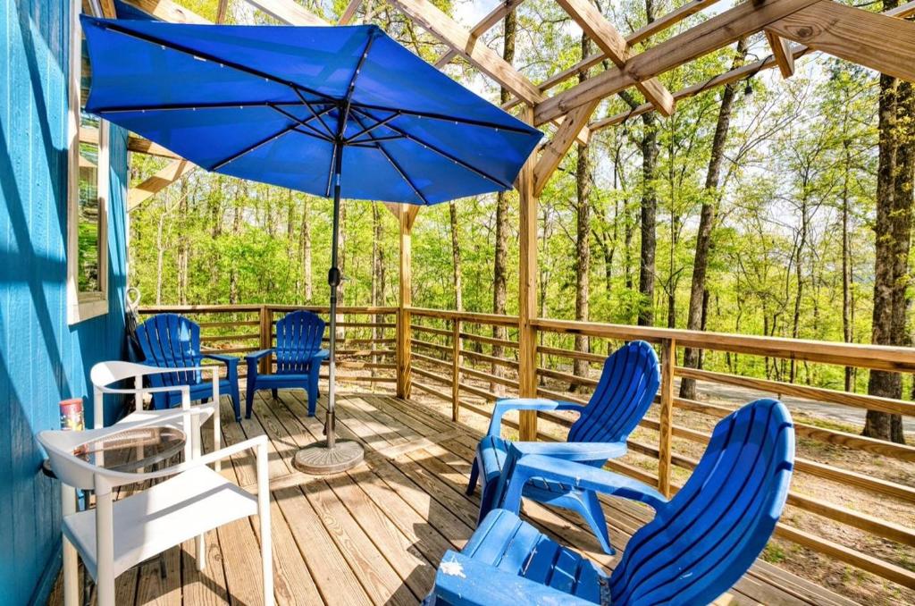 a deck with blue chairs and an umbrella at Blue Bungalow Lake Hamilton in Hot Springs