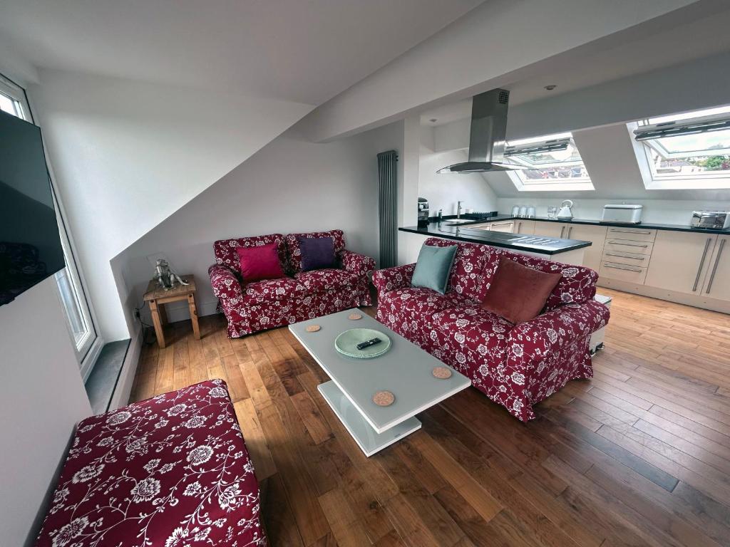 a living room with two couches and a table at Seascape Penthouse with Free Parking in Plymouth