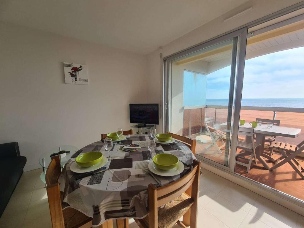 une salle à manger avec une table et une vue sur l'océan dans l'établissement Appartement Face Mer, 3 Pièces, 4 Couchages avec Balcon, Parking Privé, 2 Étoiles - Saint-Jean-de-Monts - FR-1-224C-113, à Saint-Jean-de-Monts