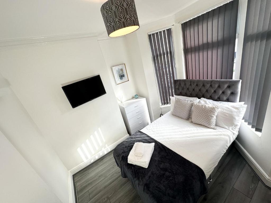 una piccola camera da letto con un letto e una televisione di Vicar Road a Liverpool