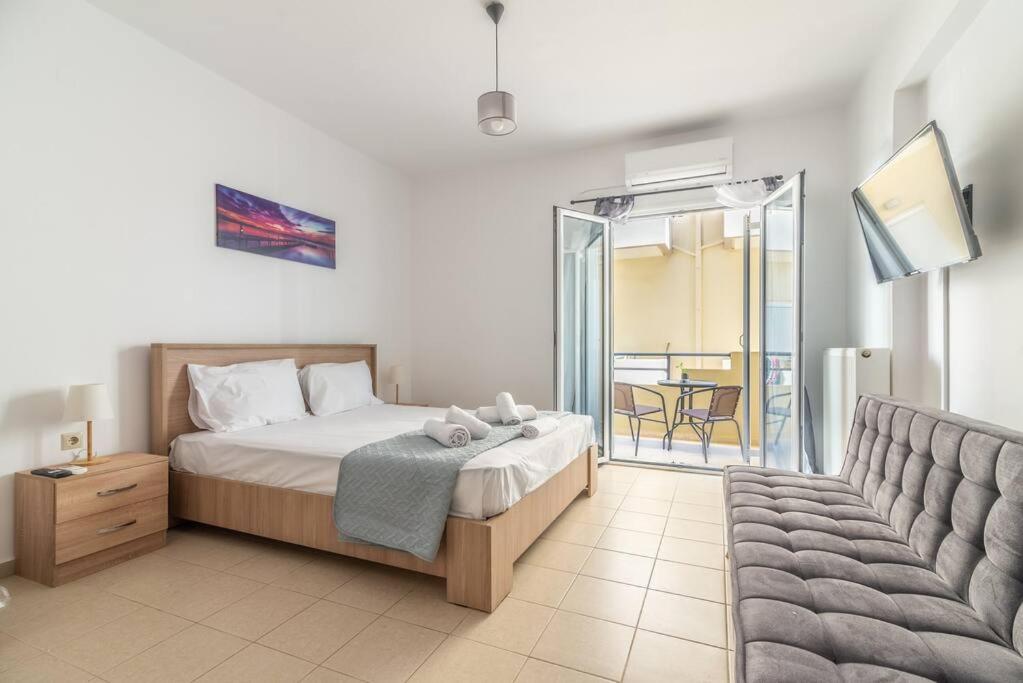a bedroom with a bed and a couch and a balcony at Urban Apt Next University 14 in Heraklio