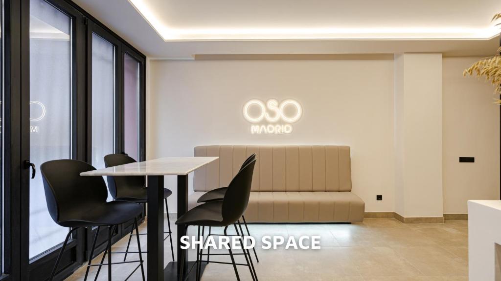 een kamer met een tafel en stoelen en een bank bij Oso Madrid Studios in Madrid