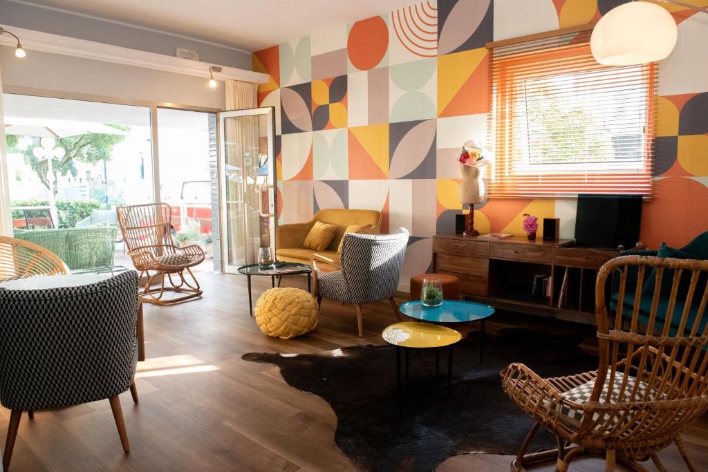 una sala de estar con paredes y sillas de colores estampados. en Hotel Mirabella, en Riccione