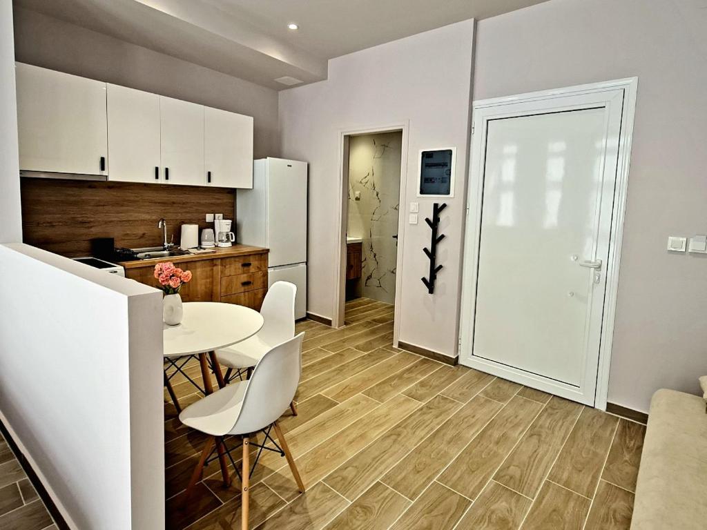 a kitchen with a table and chairs and a refrigerator at Jo's downtown modern apartment. in Ioannina