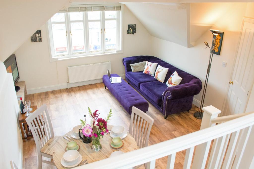 a living room with a purple couch and a table at York Terrace Apartments - Norwich City in Norwich