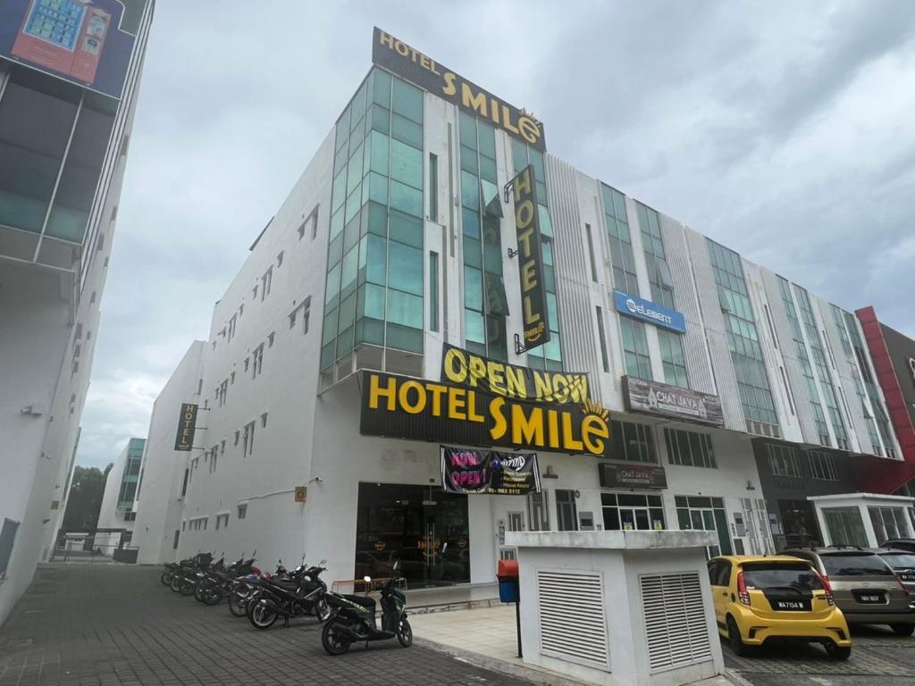 a hotel with motorcycles parked in a parking lot at Smile Hotel Subang Airport in Shah Alam