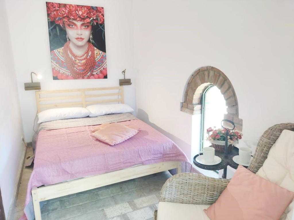 een slaapkamer met een bed en een schilderij aan de muur bij Relais Casale Il Poggetto - OLEANDRI in Cecina
