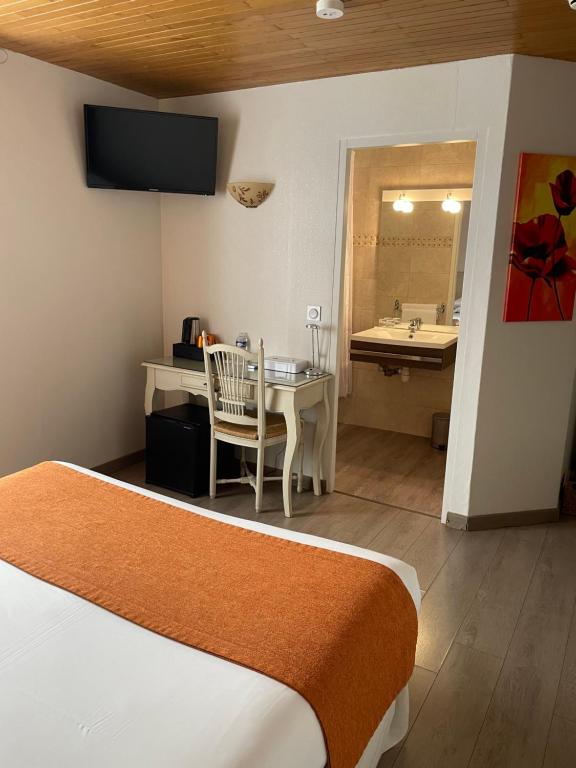 a hotel room with a bed and a desk and a sink at Hôtel Le Médiéval Palais des Papes in Avignon