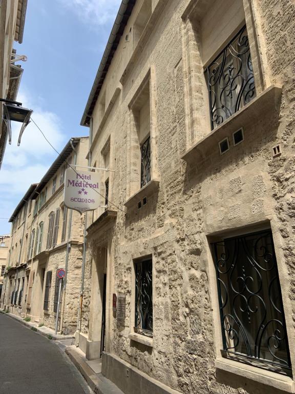 a building with a sign on the side of a street at Hôtel Le Médiéval Palais des Papes in Avignon