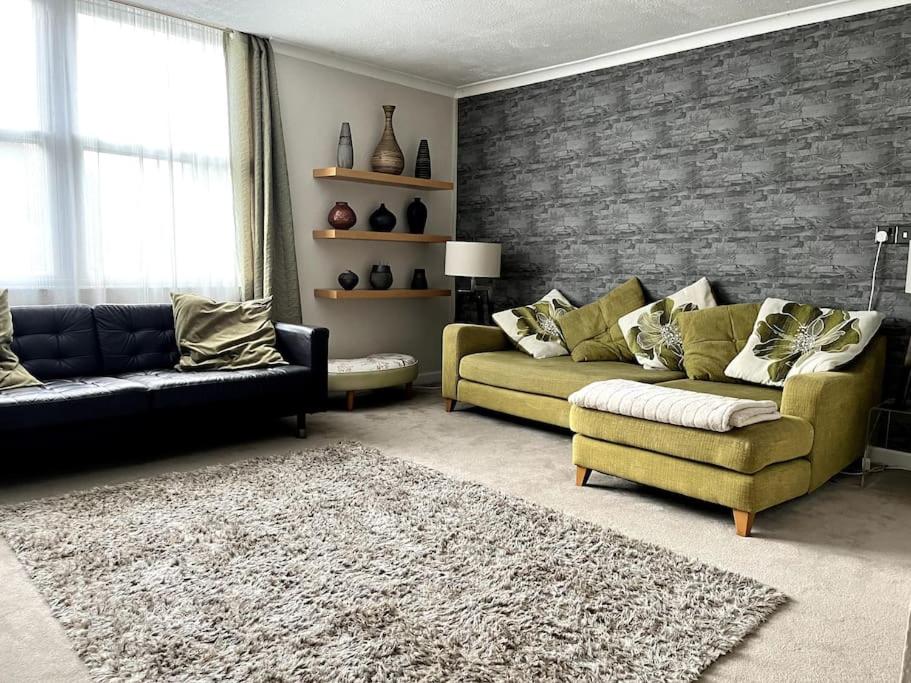 a living room with two couches and a brick wall at Riverside Apartment in Uny Lelant