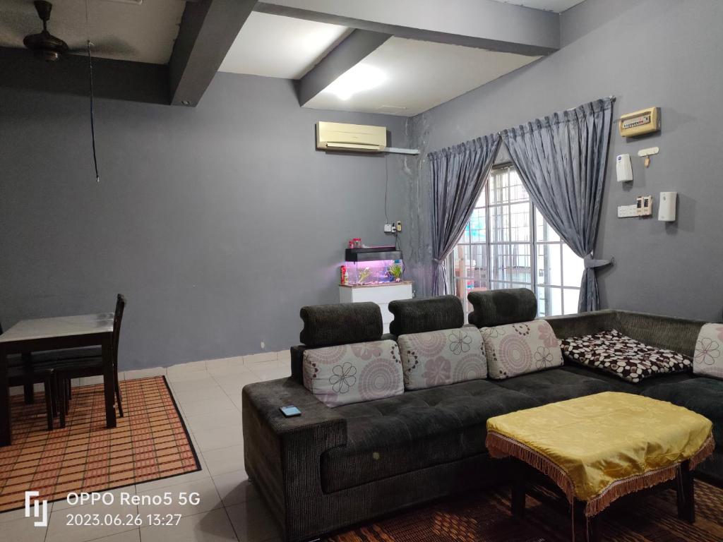 a living room with a couch and a table at TulipVilla Homestay in Kampong Parit