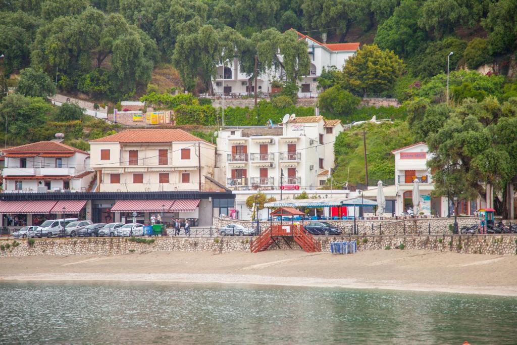 um grupo de edifícios numa praia junto à água em Avlonitis Rooms em Parga