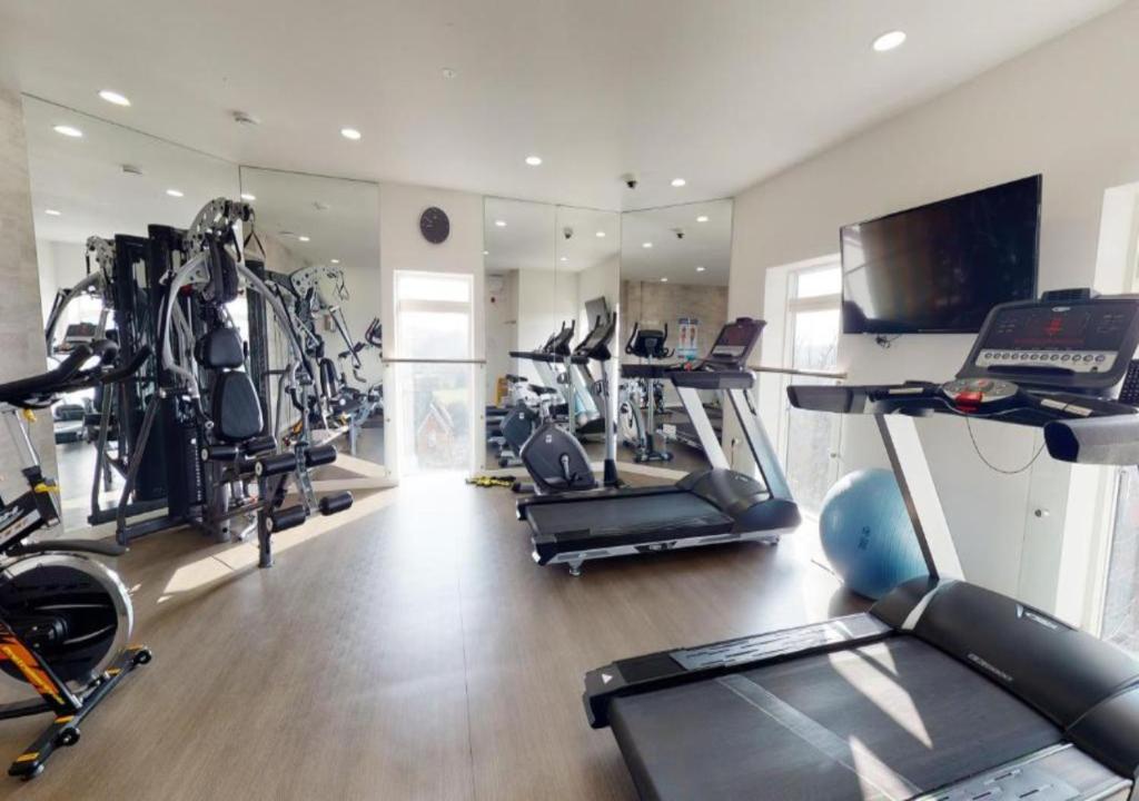 a gym with several treadmills and exercise bikes at Luxury 1-Bed Town Centre Platform South Stevenage in Stevenage