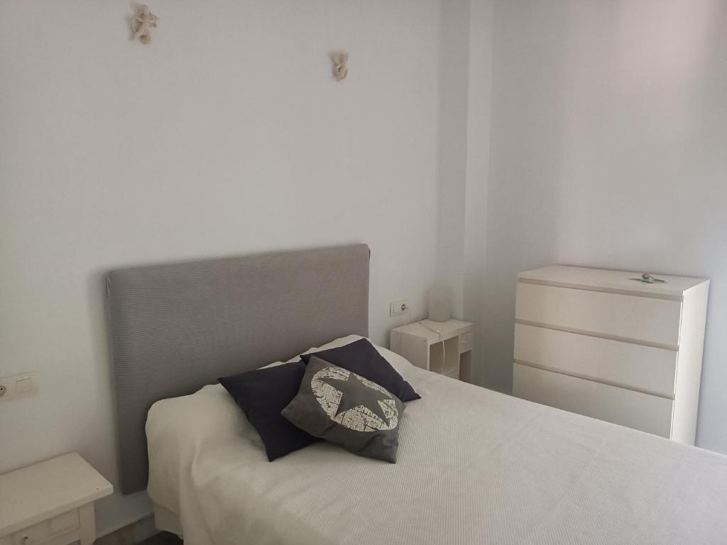 1 dormitorio con cama blanca y almohada en Islantilla - Bajo con Jardín en Golf Islantilla, en Huelva