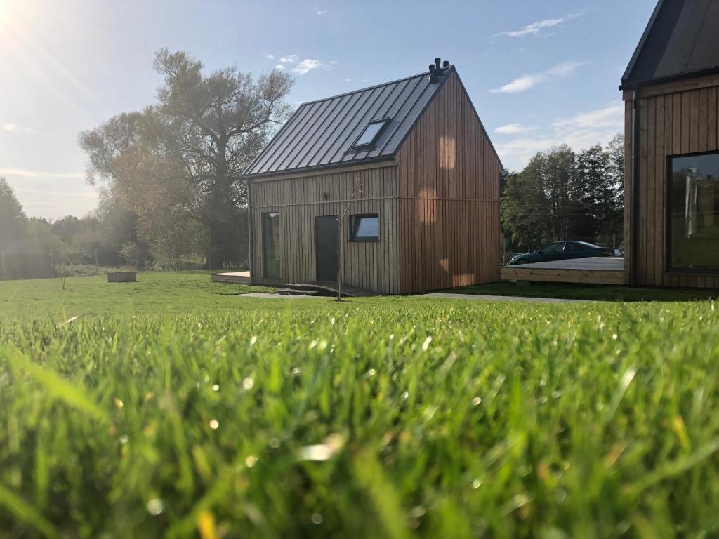 a large wooden house in a field of grass at Osada Ladimorg in Moryń