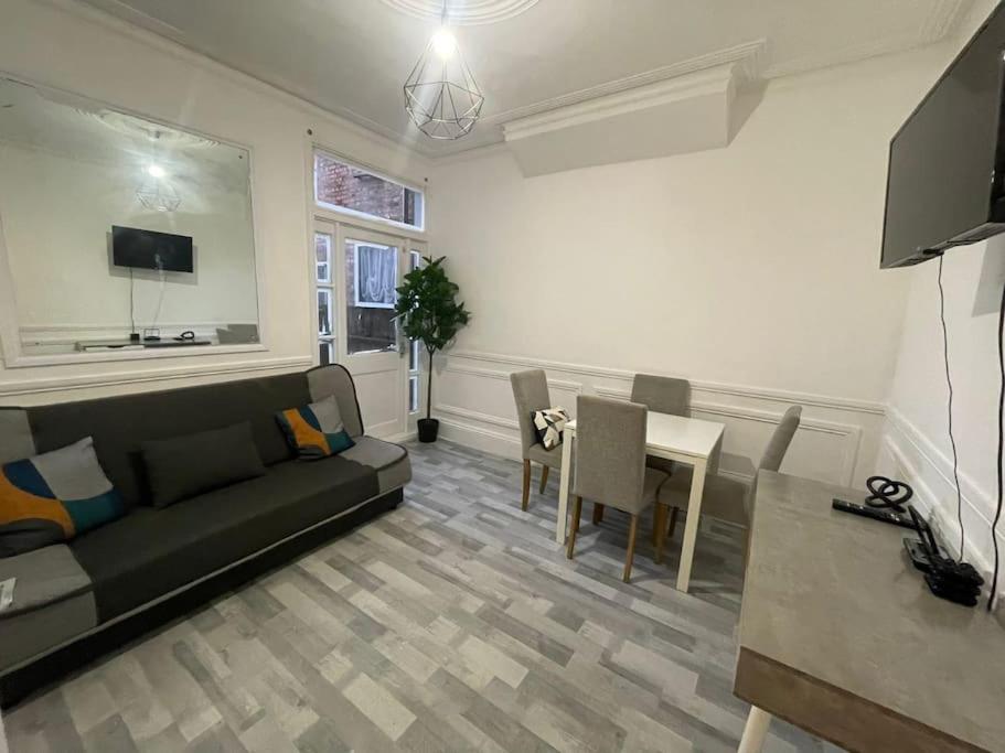 a living room with a couch and a table at Ground Floor 2 Bed Flat with Garden North London in London