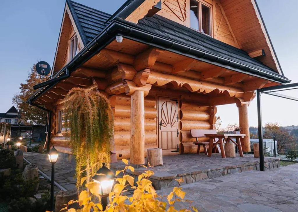 a log cabin with a table in front of it at Domek drewniany - Czerwienne in Czerwienne