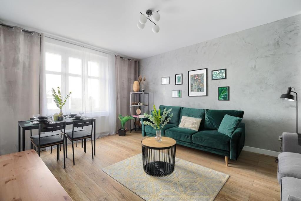 a living room with a green couch and a table at Urban Garden Hetmańska 3 in Poznań