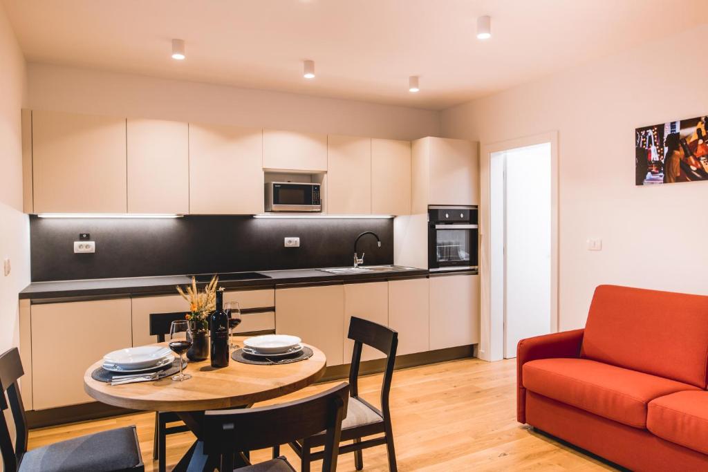 a kitchen and living room with a table and a couch at Vina Kobal, Kobal Family Estate in Štanjel