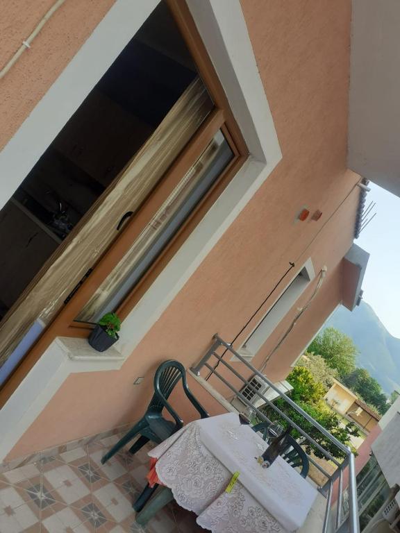 a table and a chair on a balcony with a window at Orikum beach in Orikum