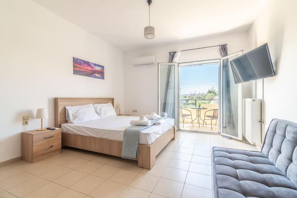 a bedroom with a bed and a couch and a window at Urban Apt Next University 4 in Heraklio Town