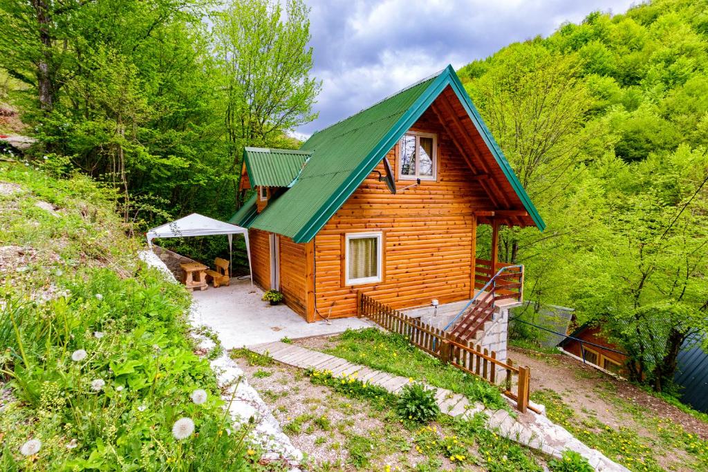 une petite cabane en bois avec un toit vert dans l'établissement Brvnare 3 zvezde brvnara Veljko, à Kokin Brod