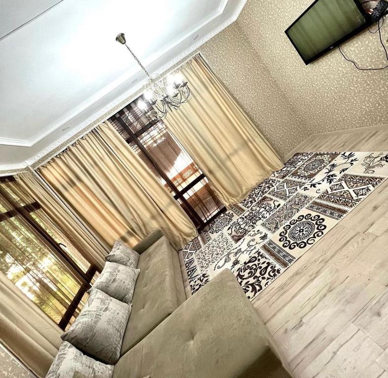 ein Wohnzimmer mit einem Sofa und einem großen Fenster in der Unterkunft Сдается коттедж на берегу озера Иссык Куль in Chon-Sary-Oy