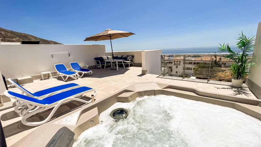 a hot tub on a patio with chairs and an umbrella at La Serena Mar, Benalmadena Pueblo, Luxury Apartment with Jacuzzi in Benalmádena