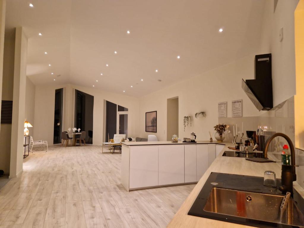 een grote keuken en een woonkamer met witte muren bij Lorans in Perstorp