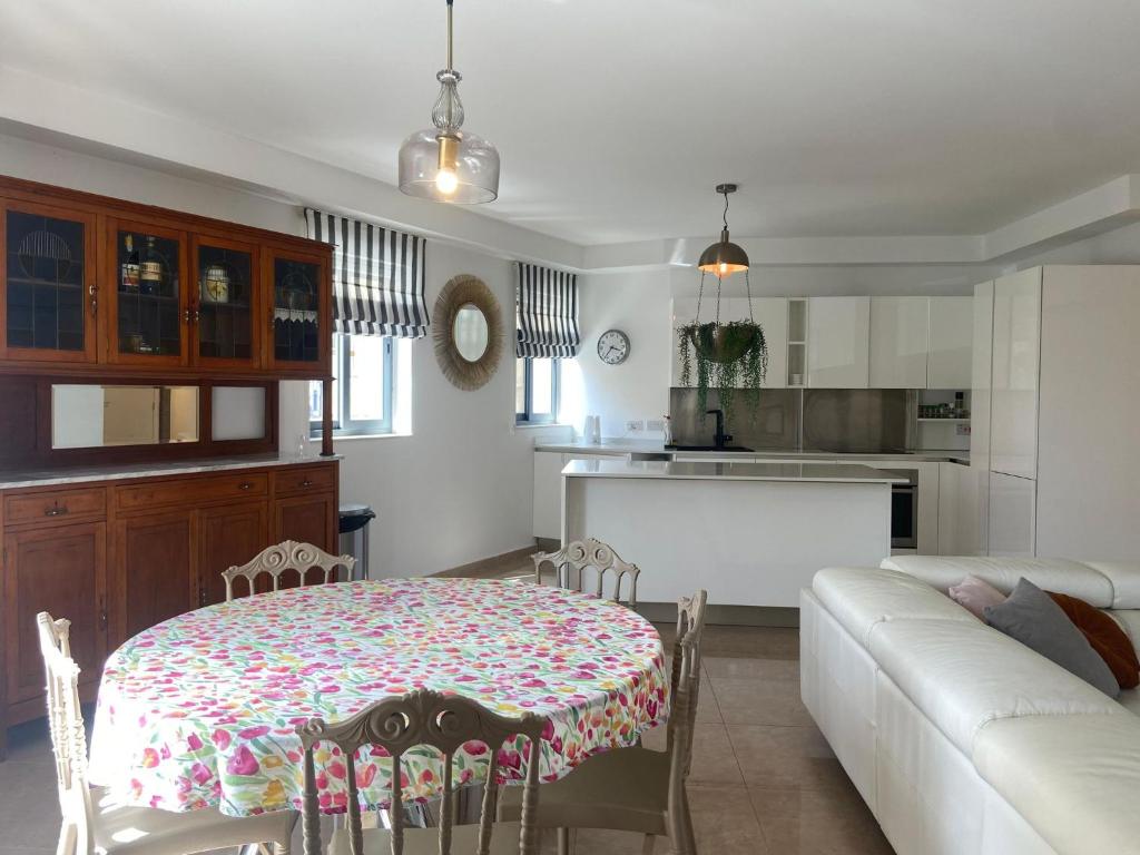 a kitchen and living room with a table and a couch at Cozy 2 bedroom Apartment near Seafront in Il-Gżira