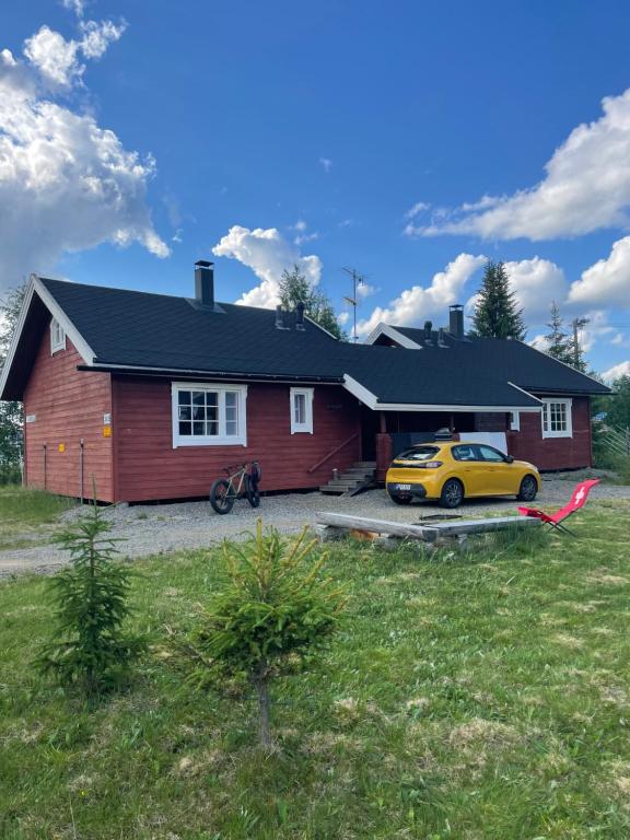 a house with a yellow car parked in front of it at Yllästölli 2 A, Äkäslompolo in Kolari