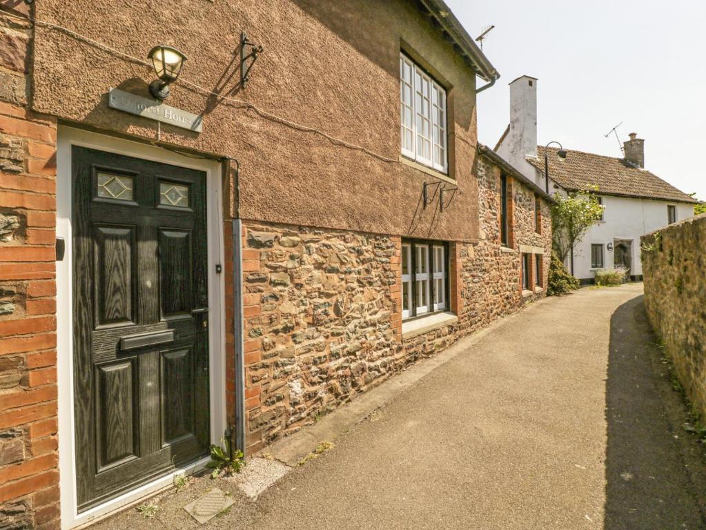 a brick building with a black door on a street at Oxford House in Minehead